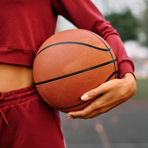 woman-holding-basketball-outdoors-close-up_23-2148773345